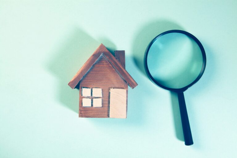 House model with magnifying glass representing what a home inspection includes